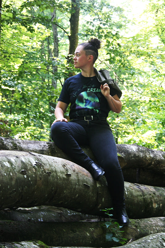 Femme assise portant un tshirt noir motif cheval et aurores boréales