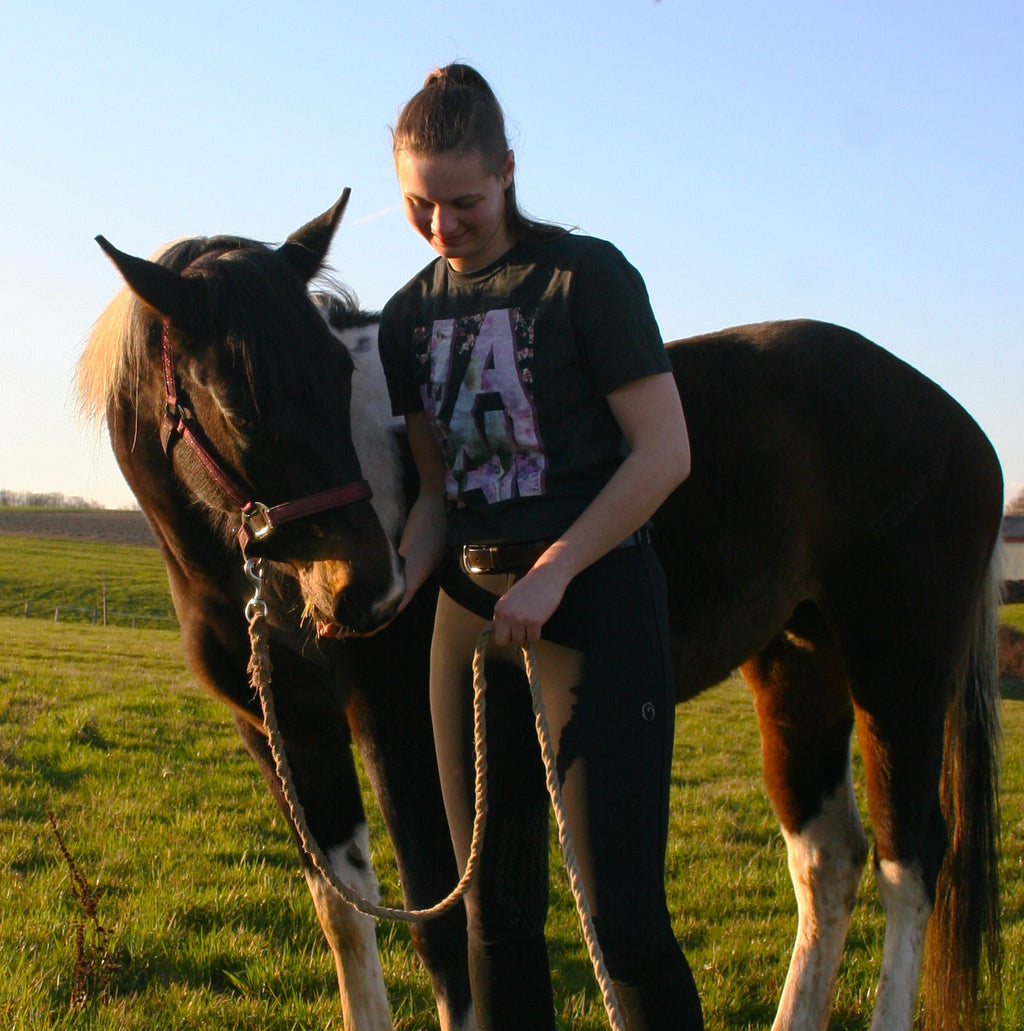 Un cheval avec sa cavalière qui porte un t-shirt sur le thème du Japon et du cheval. Les motifs du t-shirt sont japonais, avec des fleurs de cerisiers et un cheval.