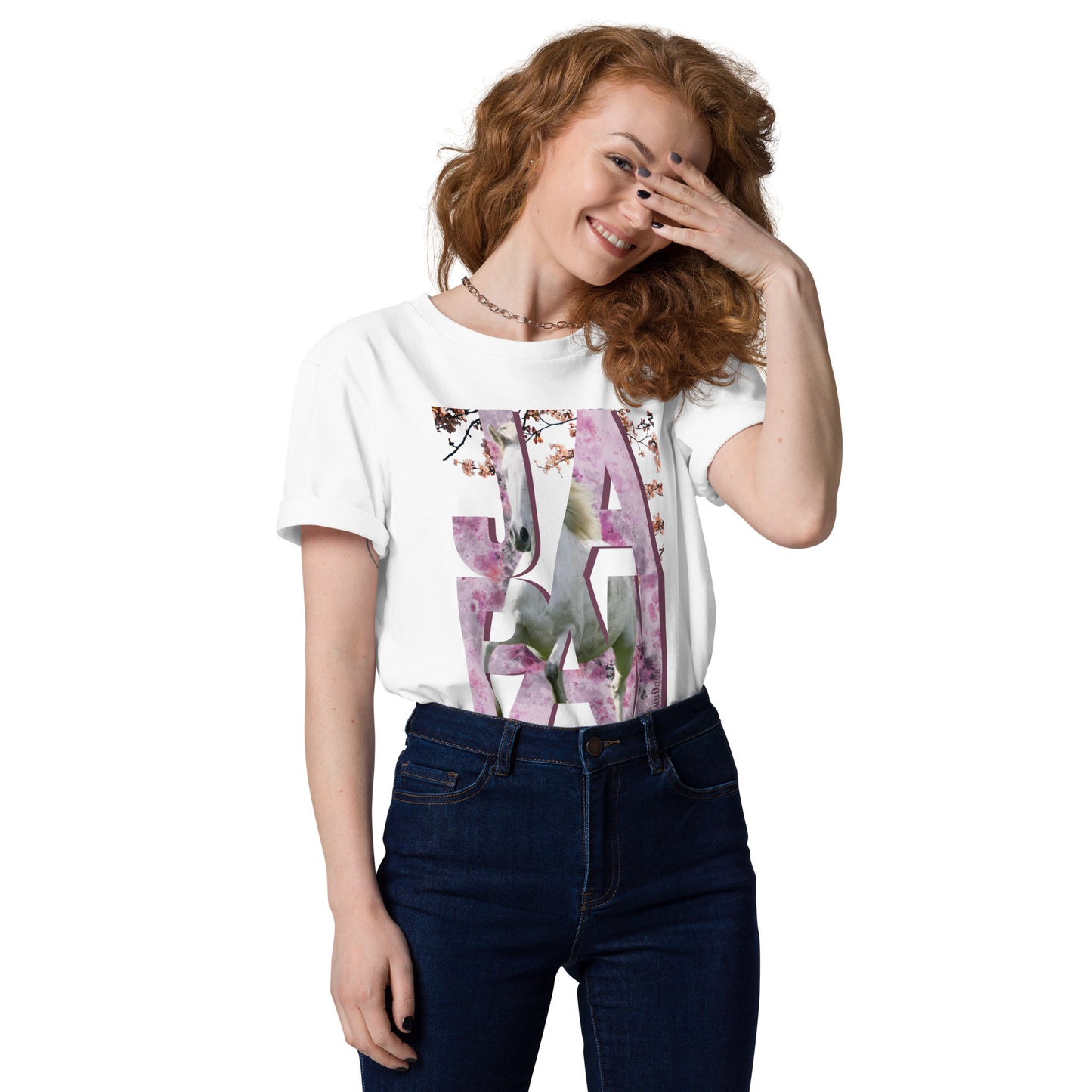 Femme souriante portant un t-shirt blanc orné d’un visuel rose avec des lettres "JAPAN" et un cheval intégré dans le design – collection YuuDada