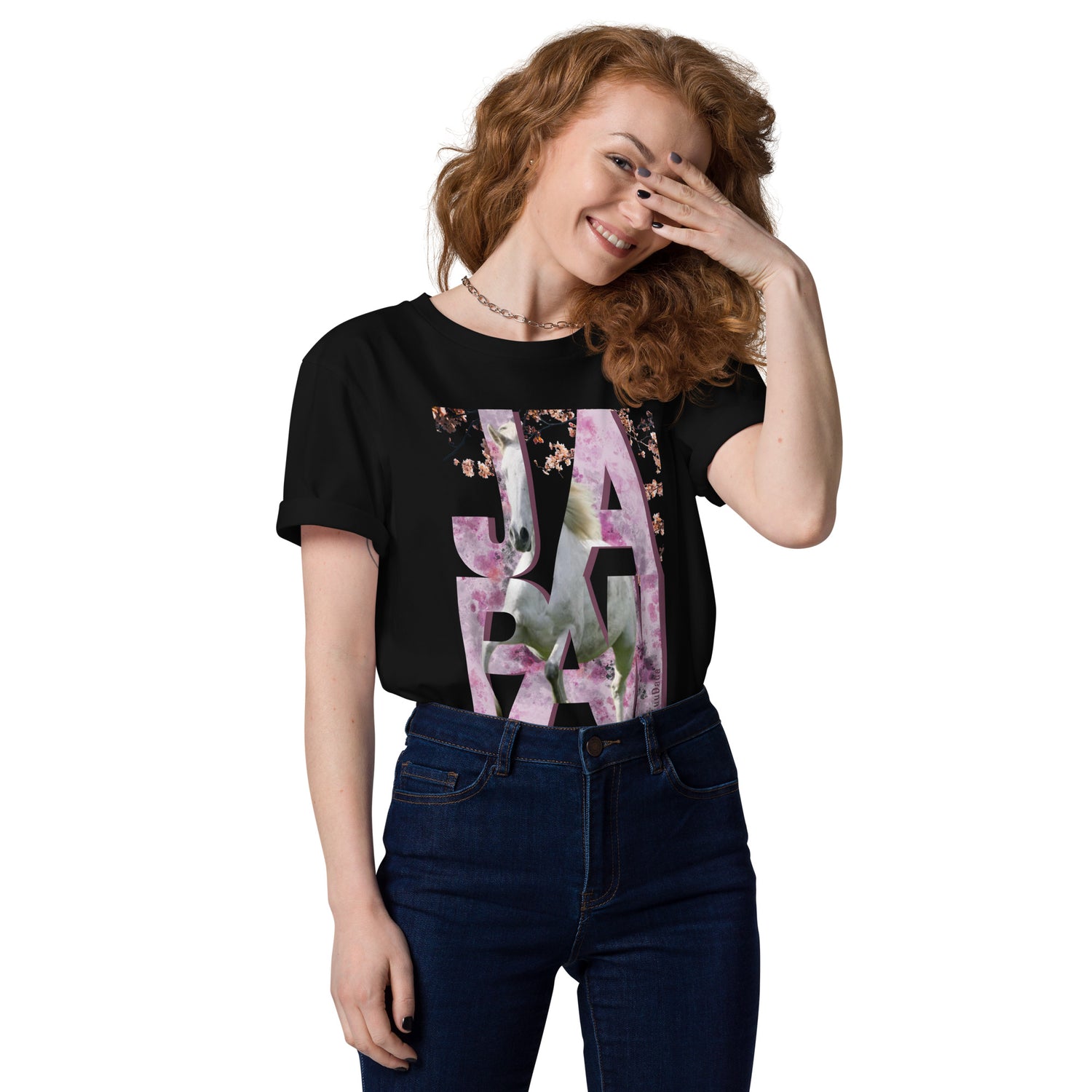 Femme souriante portant un t-shirt noir orné d’un visuel rose avec des lettres "JAPAN" et un cheval intégré dans le design – collection YuuDada
